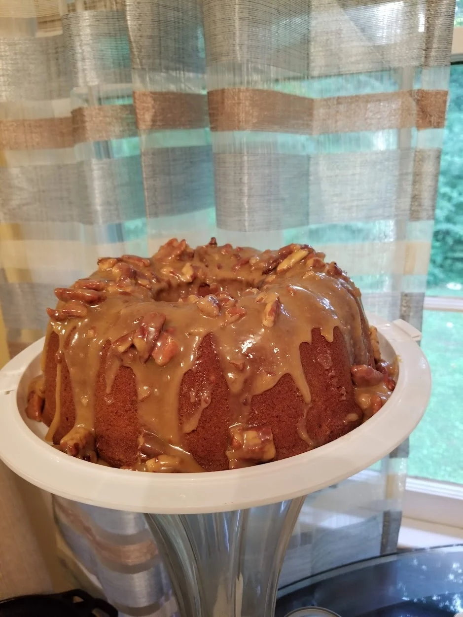 Whole pecan praline pound cake topped with pecans and glaze